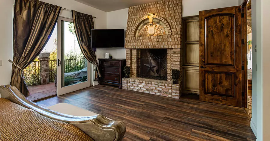 master-bedroom-brick-fireplace-wood-floors