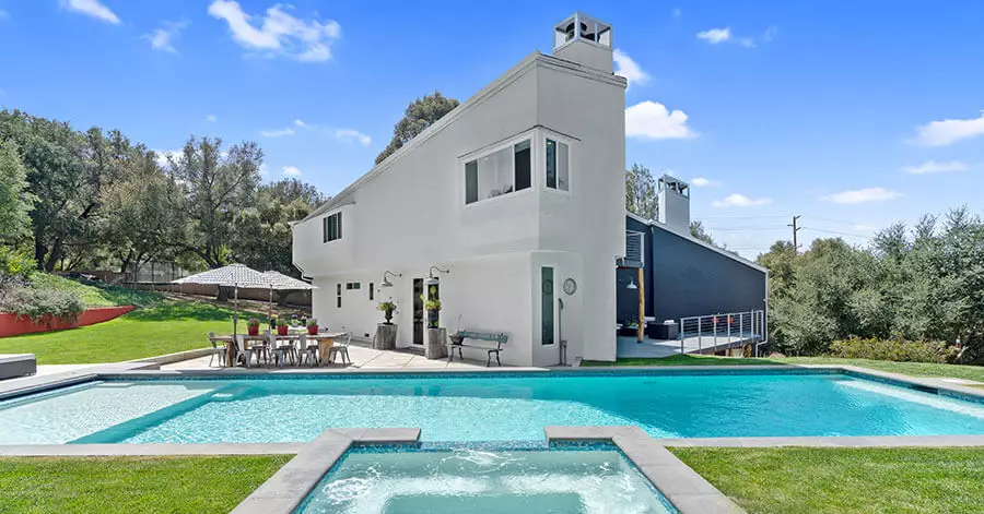 view of home from the pool and spa