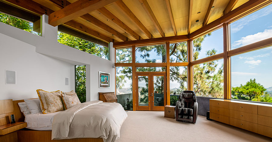 master bedroom with curved wall of glass windows 