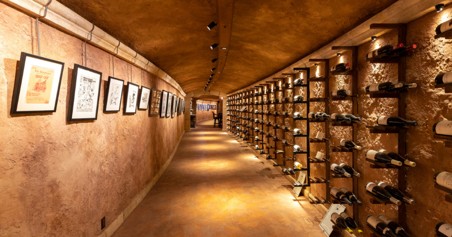 Hallway in a subterranean Kiva wine cave featuring artwork and wine bottles