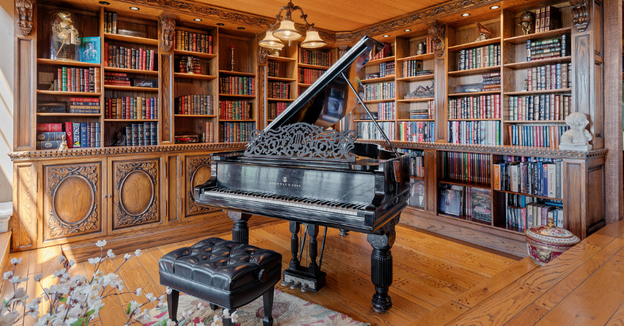 library and grand piano with striking wooden carved bookcases