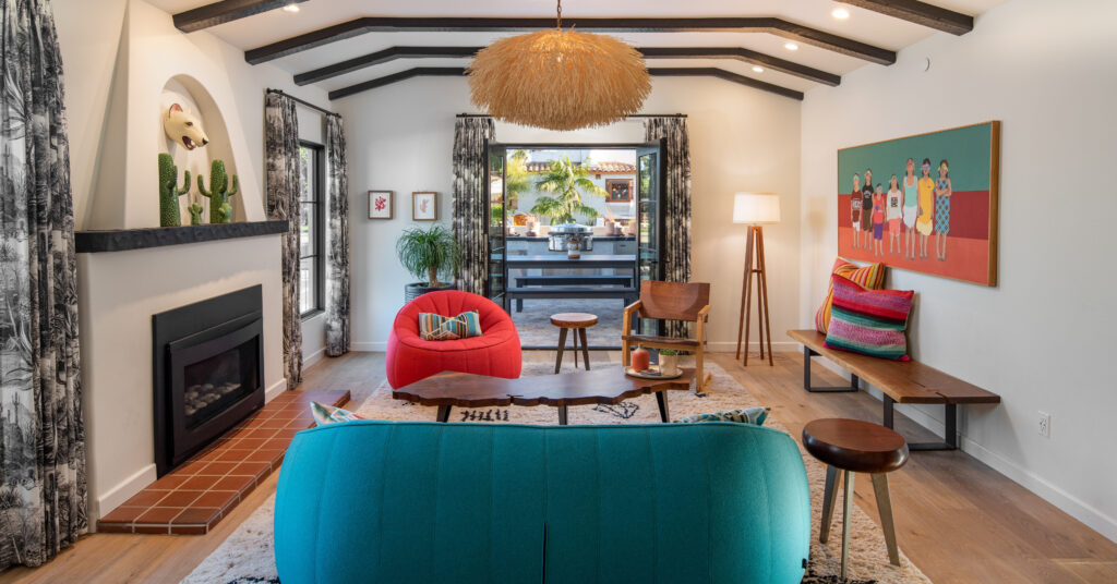 Original fireplace from 1927 and beamed ceilings in a stylish, colorful living room. 