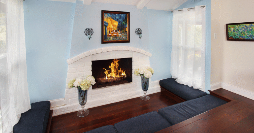 Sunken floors and seating surround blue wall with white brick fireplace