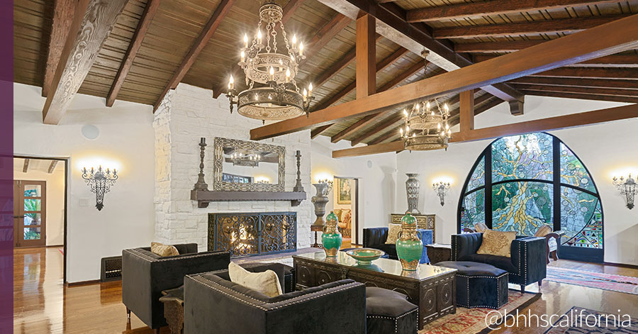 Living room featuring prominent fireplace with elegant Spanish-style decor. 