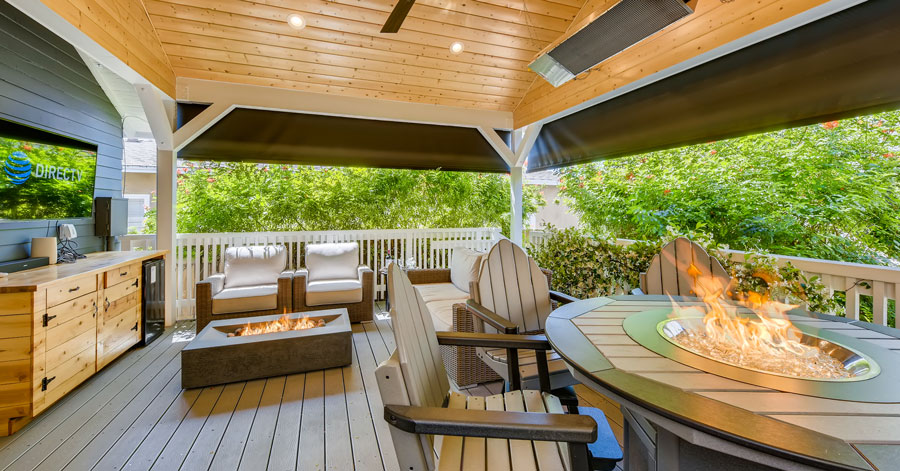 Covered outdoor patio with seating area and firepit. 