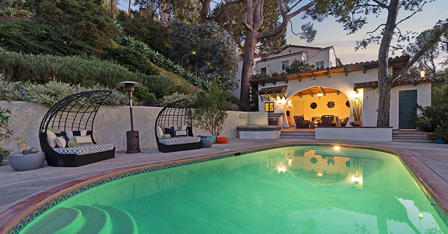 View of Misha Collins home from far side of pool at dusk 