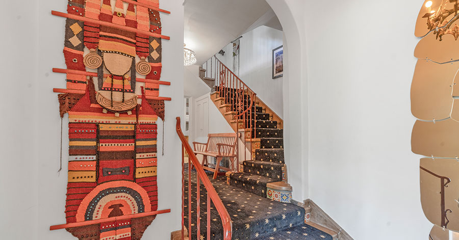 Artistic shot of staircase and arched ceilings, artwork displayed prominently on walls 