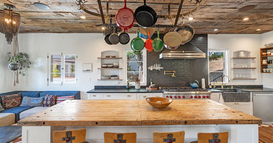 View of kitchen stove and counter, lounge area, from across kitchen island 