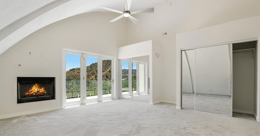 Inside master bedroom looking out window and balcony at canyon outside