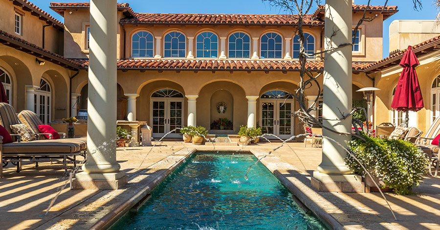 View of vineyard estate with pool, columns, and fountains in the foreground 