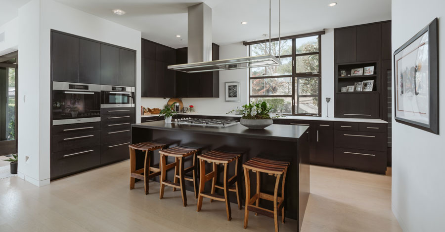 Dark cabinets in a modern kitchen with large black kitchen island