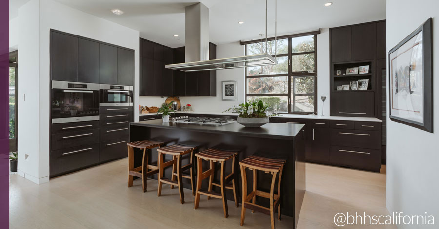 Kitchen island with dark cabinets and county. 