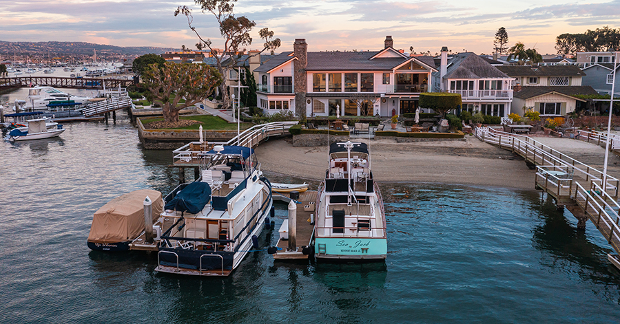 Aerial view from end of dock looking at Newport Beach bayfront home. 