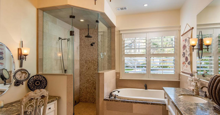 bathroom with glass shower, soaking bathtub, sink, vanity, and tapestry art on wall