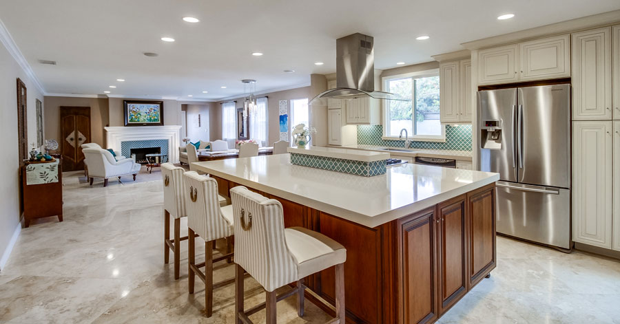 remodeled kitchen found in open floor plan with an island and white cabinetry