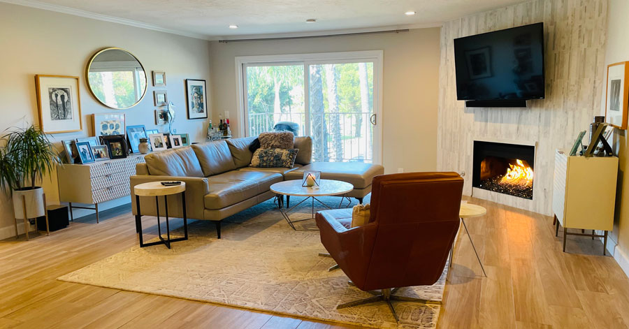 remodeled living room with couch, chair, fireplace, and cabinets