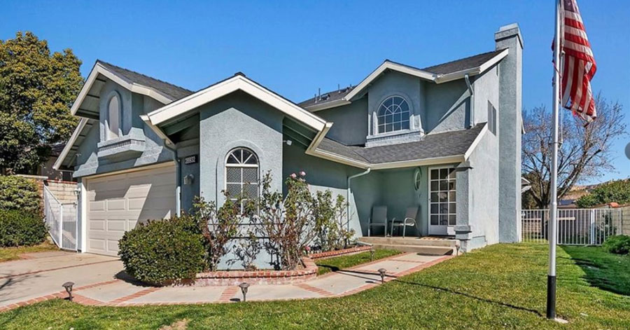 remodeled homes in southern california - light blue exterior of house with many windows and American flag