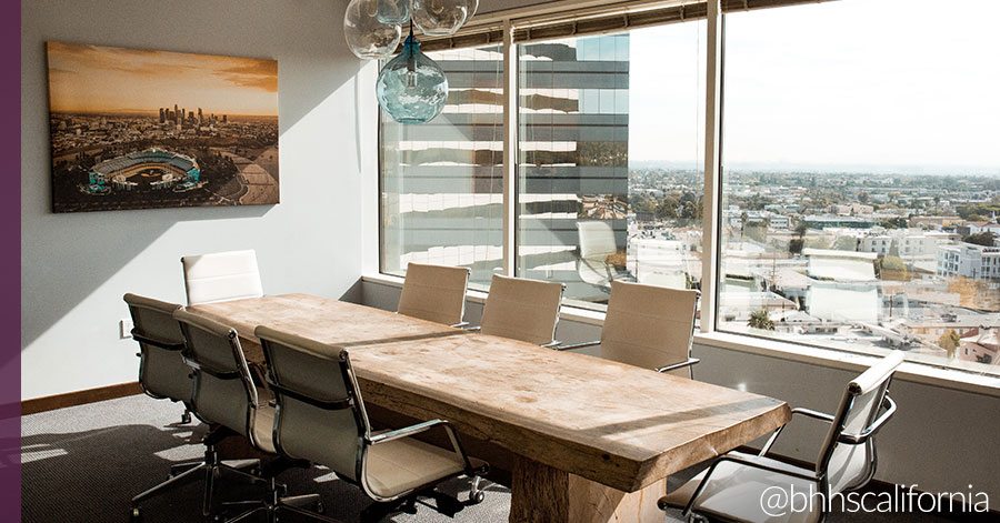 View of Los Angeles office with large conference table and view of city below. 