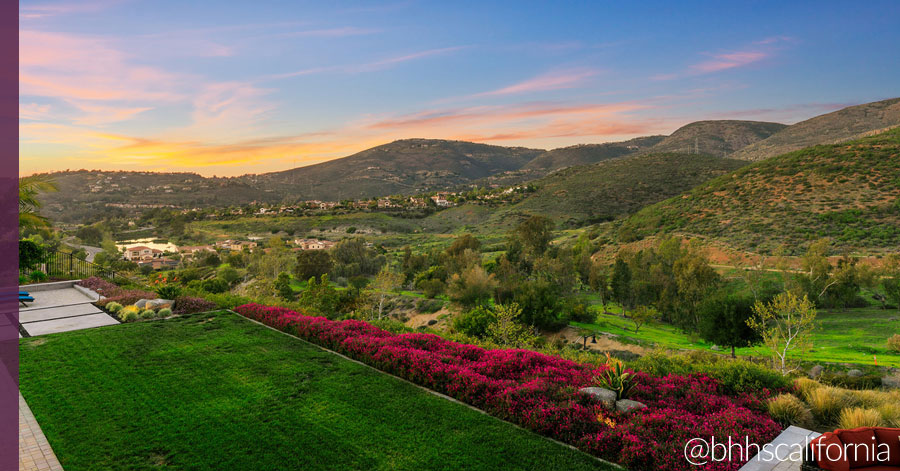 Southern California garden and lush green back yard with mountains and sunset in the distance 