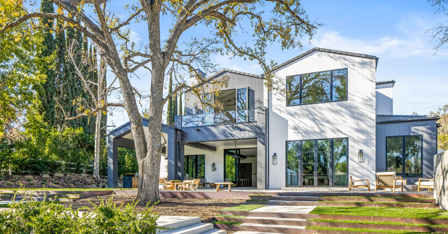 Backyard view of a modern Hidden Hills home with white and grey-blue exterior. 