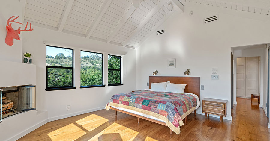 Bedroom with wooden floors and vaulted white wooden ceiling 