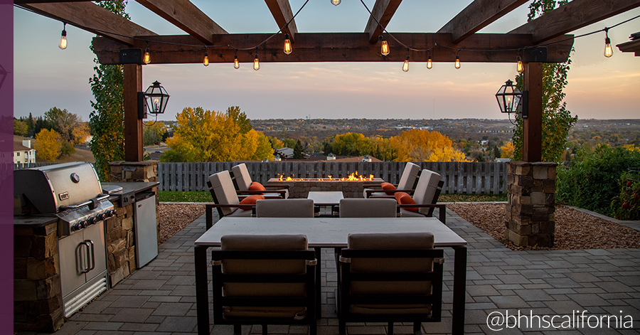 backyard featuring some of the ultimate summer home features: pergola, fire pit, built-in kitchen. 