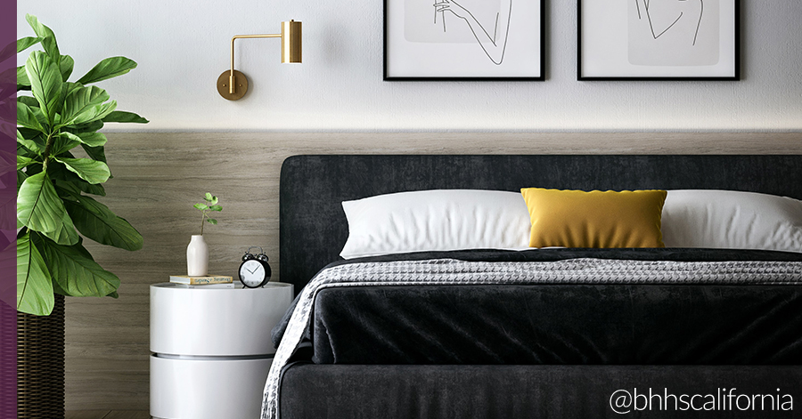 Modern bedroom with dark bedding, light wood paneling and brass wall mounted lamp - ideas to give your bedroom a refresh 