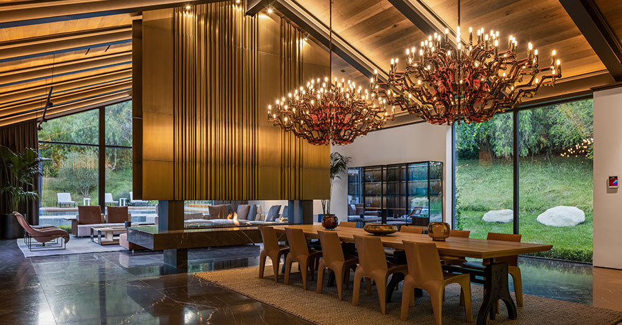 dining room with impressive large chandeliers and wood paneling details 