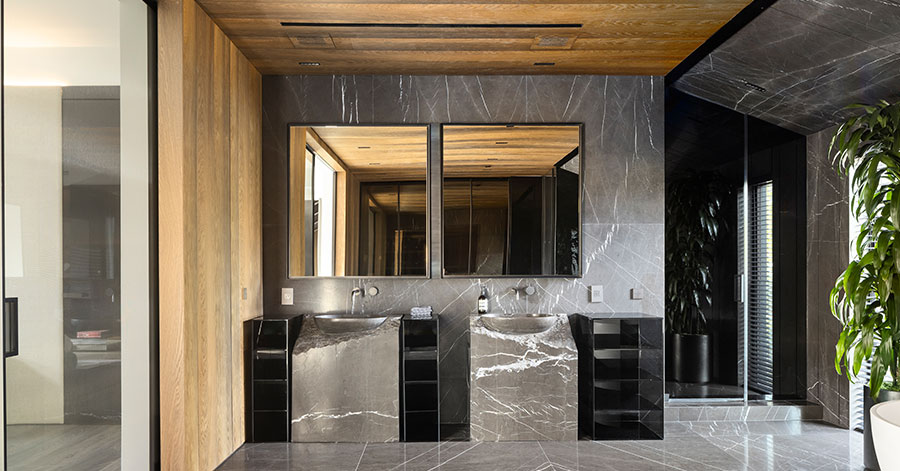 Modern dual sinks in a dark grey marble bathroom 