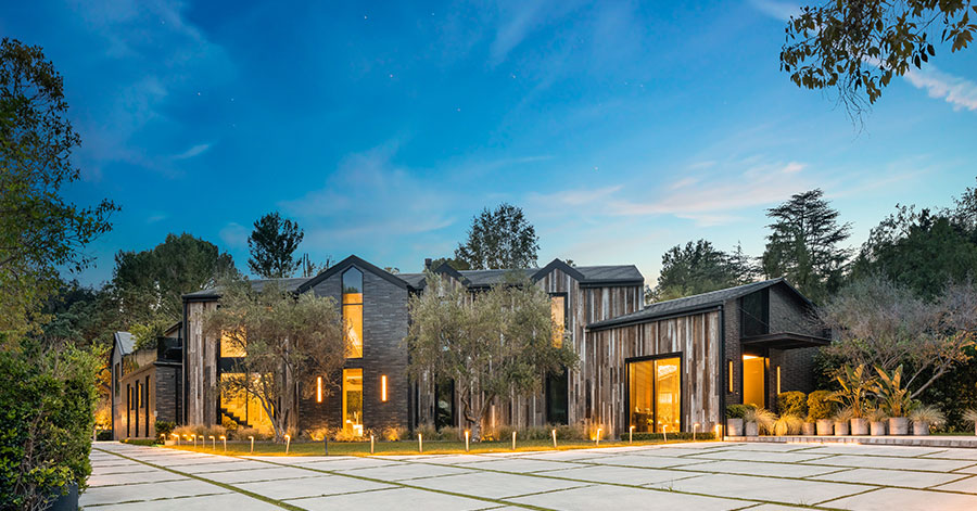 Exterior of NBA star Ben Simmons Hidden Hills home with vertical wood paneling and black accents on windows and roof 