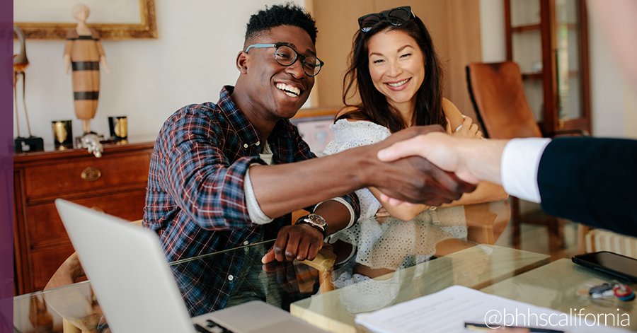 Two home buyers shaking hands with their agents in a real estate office - What is a contingency sale