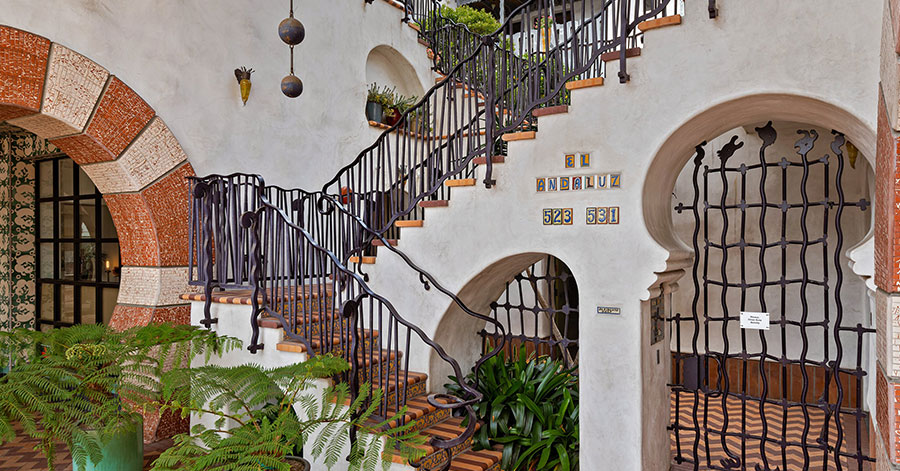 wrought iron staircase and colorful tiled steps with "el andaluz" spelled out in tiles of wall - entry of iconic el andaluz designed by jeff shelton 