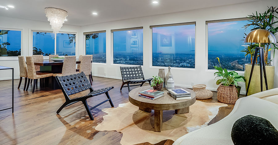 Living room of former home of The Doors’ John Densmore with large windows that overlook city of LA 