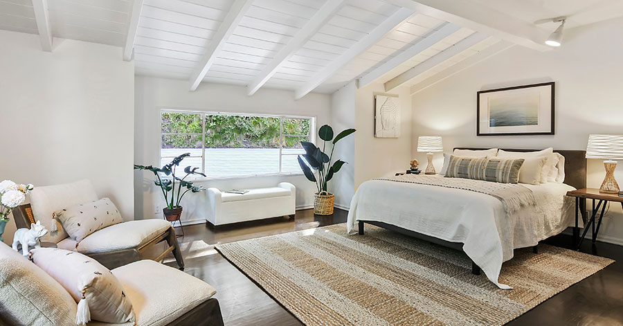 spacious bedroom with vaulted ceilings and natural light