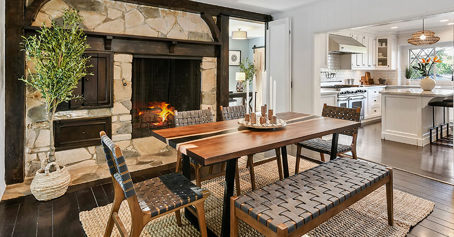 Dining area with large stone and wood fireplace 