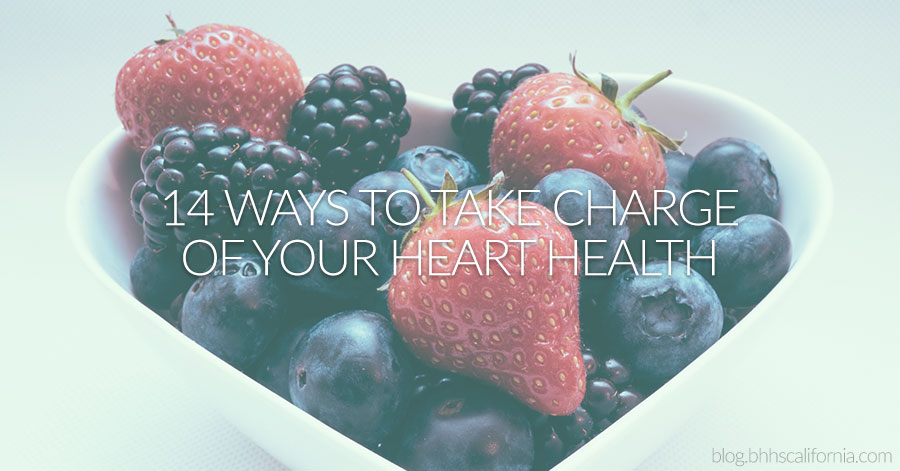 Heart-shaped bowl of berries with text that reads 14 ways to take charge of your heart health