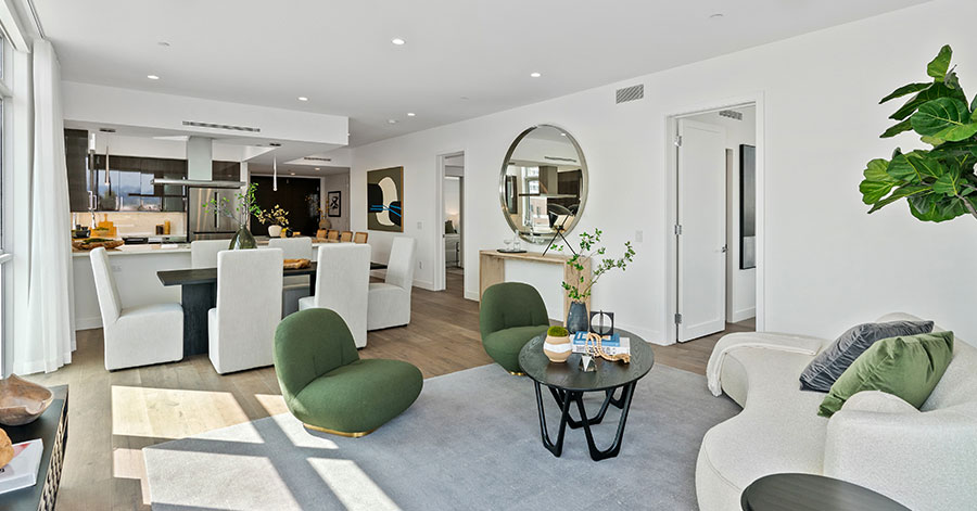 Interior view of living room, dining room, and kitchen in modern apartment with natural sunlight 