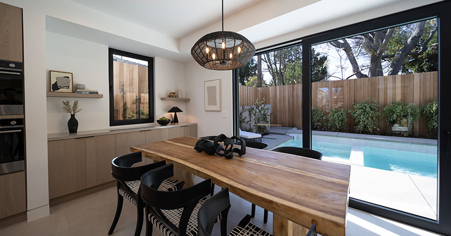 shot of dining table and floor to ceiling windows that leads to the pool 