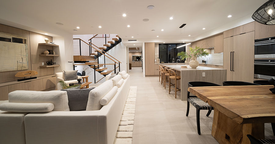 Interior shot that show main floor including dining area, living area, kitchen, staircase, and hallway leading to front door 